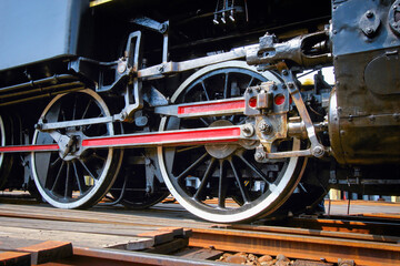 A close-up view of the drive wheels and connecting rods of a vintage steam locomotive at the historic Changhua Roundhouse in Changhua City, Taiwan.
