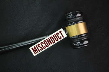 Judge's gavel and colored paper with the word misdemeanor. unacceptable or improper behavior,...