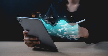 A person interacts with a tablet, analyzing futuristic digital data visualizations with a stylus.