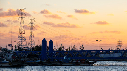electricity pylon on the sea during sunset