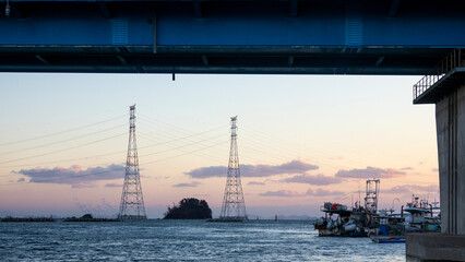 electricity pylon and bridge on the sea
