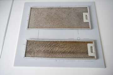 Dirty metal exhaust filter long overdue for cleaning on table before replacement in kitchen. Health...