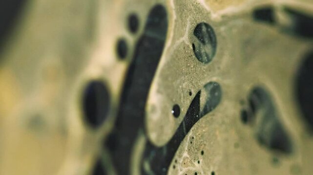 Vertical video. Serum blob. Blur fizzy liquid. Defocused yellow black color round oil bubbles floating mist texture fluid ink spill drip paint water flow on abstract art background.