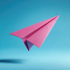 A vibrant pink paper airplane, sharply folded, floats against a bright blue backdrop, casting a subtle shadow below