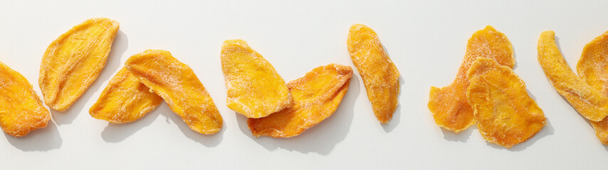 Dried mango chips on a white background
