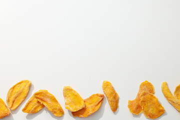 Dried mango chips on a white background