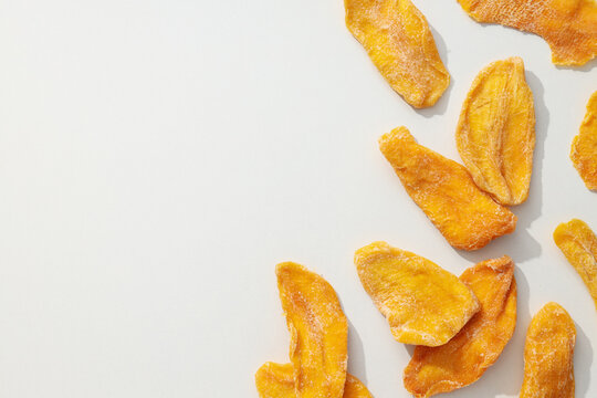 Dried mango chips on a white background