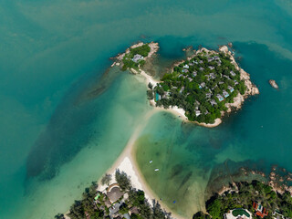 Tropical island with luxury villas surrounded by clear turquoise water, white sandy beaches, and lush greenery. Koh Samui, Thailand.