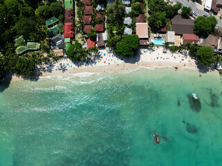 Top view of sandy beaches and resorts surrounded by palm trees and turquoise waters. Koh Samui, Thailand.