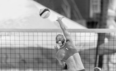 Beach Volleyball Player Female Athlete Playing Sport Spiking Volley Ball At The Net