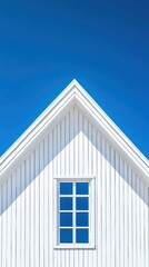 Modern minimalist white house facade with triangular roof and symmetrical window against clear blue sky, showcasing contemporary architecture and clean design