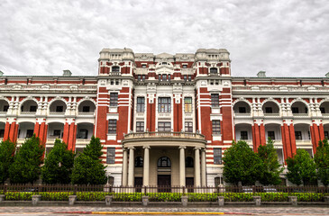 Taiwan Presidential Office Building in Taipei Zhongzheng District displays a grand Baroque-revival facade with striped pilasters, arched loggias, and a colonnaded portico, framed by manicured trees