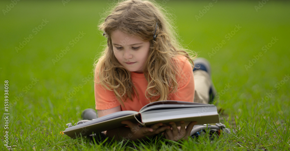 Poster child reading a book in the grass. kid enjoying a book story outdoors. child studying with book in t