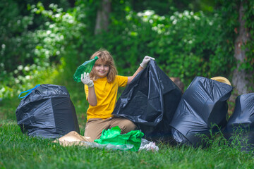 Kid in rubber gloves with trash bag clean up garbage on forest outdoor. Eco, environment...