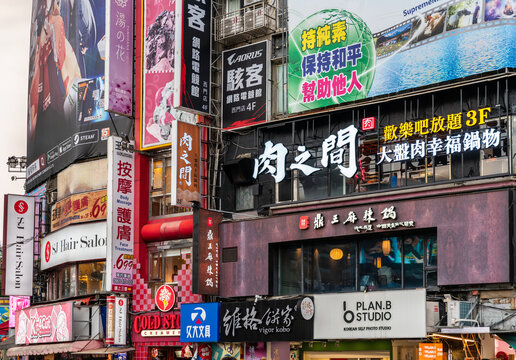 Taipei, Taiwan - April 12, 2025: Layer upon layer of neon signs, billboards, and Chinese characters cloak the multi-level shopfronts of Ximending, creating a colourful collage of cafes, restaurants