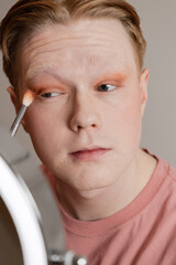 Man Applying Eyeshadow with Brush Vertical Extreme Close Up
Close-up of a young man applying...