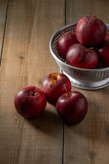 Some vibrant red apples rest on a rustic wooden background, highlighting their fresh appeal. Perfect for themes related to healthy eating, natural food, or autumn harvest.