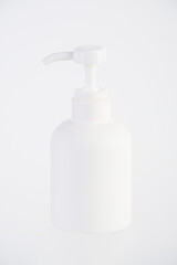 The medium-sized white bottle is a pump bottle for cream with a white background.