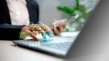 Business professional using digital tools for carbon footprint reduction, showcasing eco-friendly technology, net zero emissions, and sustainable energy data in a modern workspace.