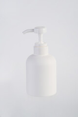 The medium-sized white bottle is a pump bottle for cream with a white background.