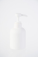 The medium-sized white bottle is a pump bottle for cream with a white background.