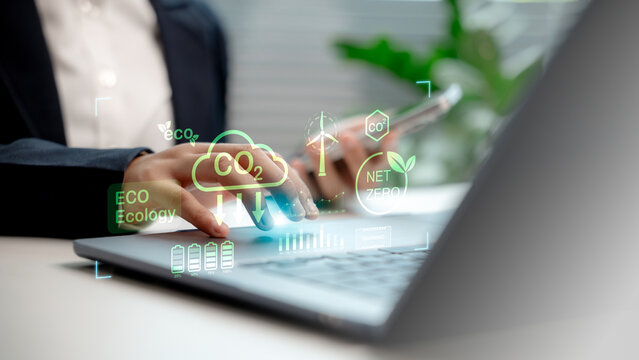 Business professional using digital tools for carbon footprint reduction, showcasing eco-friendly technology, net zero emissions, and sustainable energy data in a modern workspace.