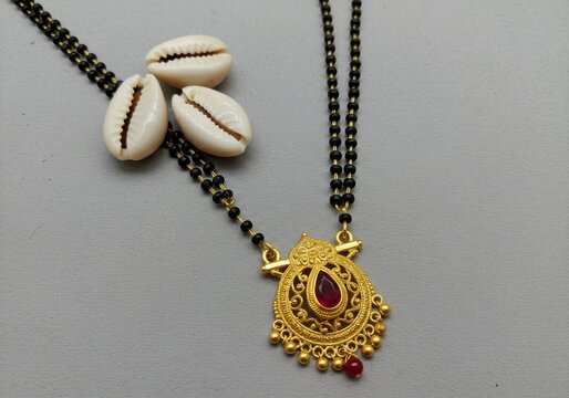Traditional mangalsutra necklace with gold pendant and red gemstone
