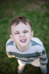 Portrait of a young boy looking up and smiling playfully at the camera 