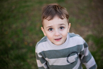 Portrait of a young boy looking up at the camera 