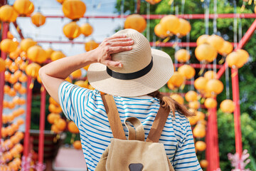 Woman enjoying view of outdoor passage decorated with lanterns