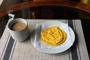 Typical Costa Rican breakfast: tortilla with egg and a glass of coffee or torta de huevo con tortilla