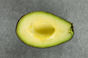 half avocado without pit on gray kitchen countertop
