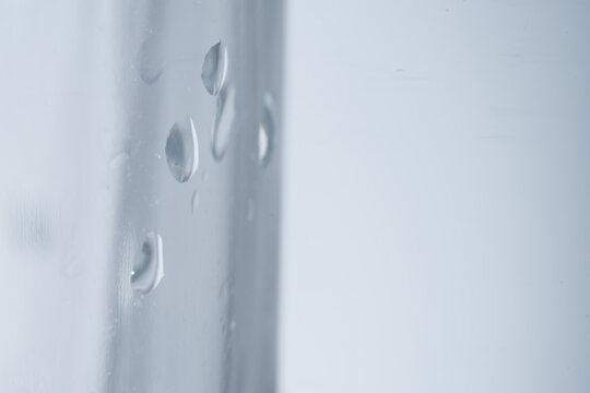 Abstract blue texture of wet glass with clean raindrops and clear water droplets on the window surface