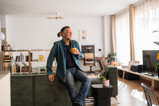 Senior man enjoying coffee in a modern living room during retirement