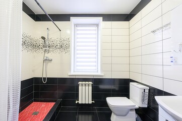 modern bathroom featuring black and white tiles, a red shower base, a window with blinds, and a white toilet and sink