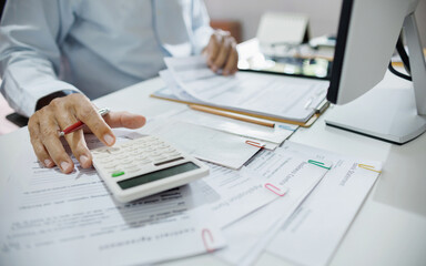 accountants working in office use calculators to calculate business costs, profits and tax