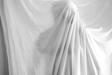 silhouette of a person against the background of a white sheet, the effect of a statue or a ghost