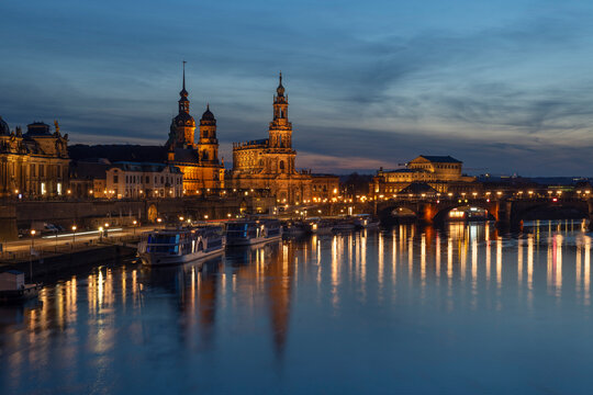 Dresden skyline at dusk with illuminated landmarks and reflections on the Elbe River