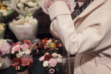 a woman chooses a bouquet of flowers in a flower shop