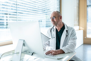 Doctor working confidently on a computer in a clinic office
