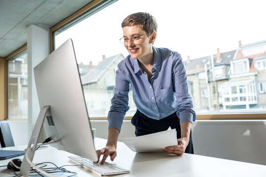 Businesswoman analyzing data on a computer in a modern office