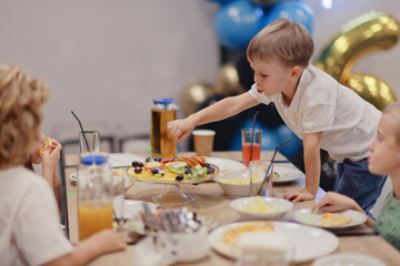 6 years old boy at a birthday party, celebration at a cafe dinner