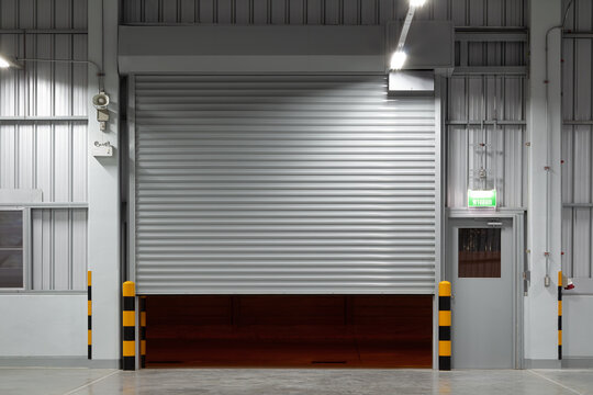 Shutter door or roller shutter inside industrial building at front. To construction for entrance of commercial, industrial building i.e. warehouse, factory, garage, hangar or shop suit for background.