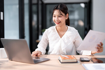 Portrait of an attractive young businesswoman working on her laptop while sitting in the office.