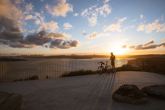 Cyclist sunset over sydney harbour at north head in manly