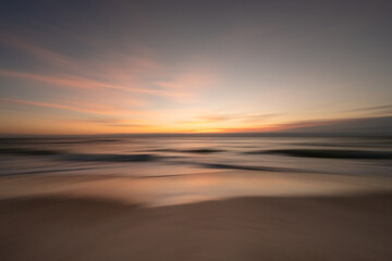 Fototapeta premium Silky smooth colorful ocean waves gently crash a tropical beach