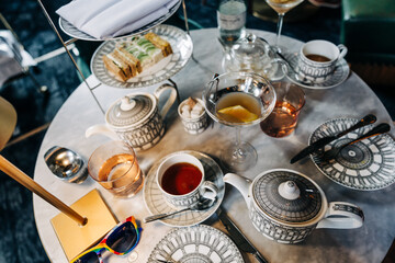 Elegant afternoon tea setup with sandwiches, teapots, and drinks
