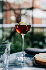 Elegant cocktail with lemon twist on glass table outdoors