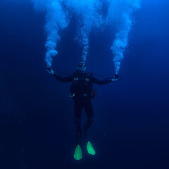 diver flippers view from the back underwater, underwater view of the back of a person swimming with scuba diving