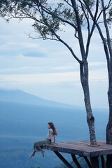 Meditation in the mountains, a girl sits on a platform in the mountains, Bali Indonesia landscape